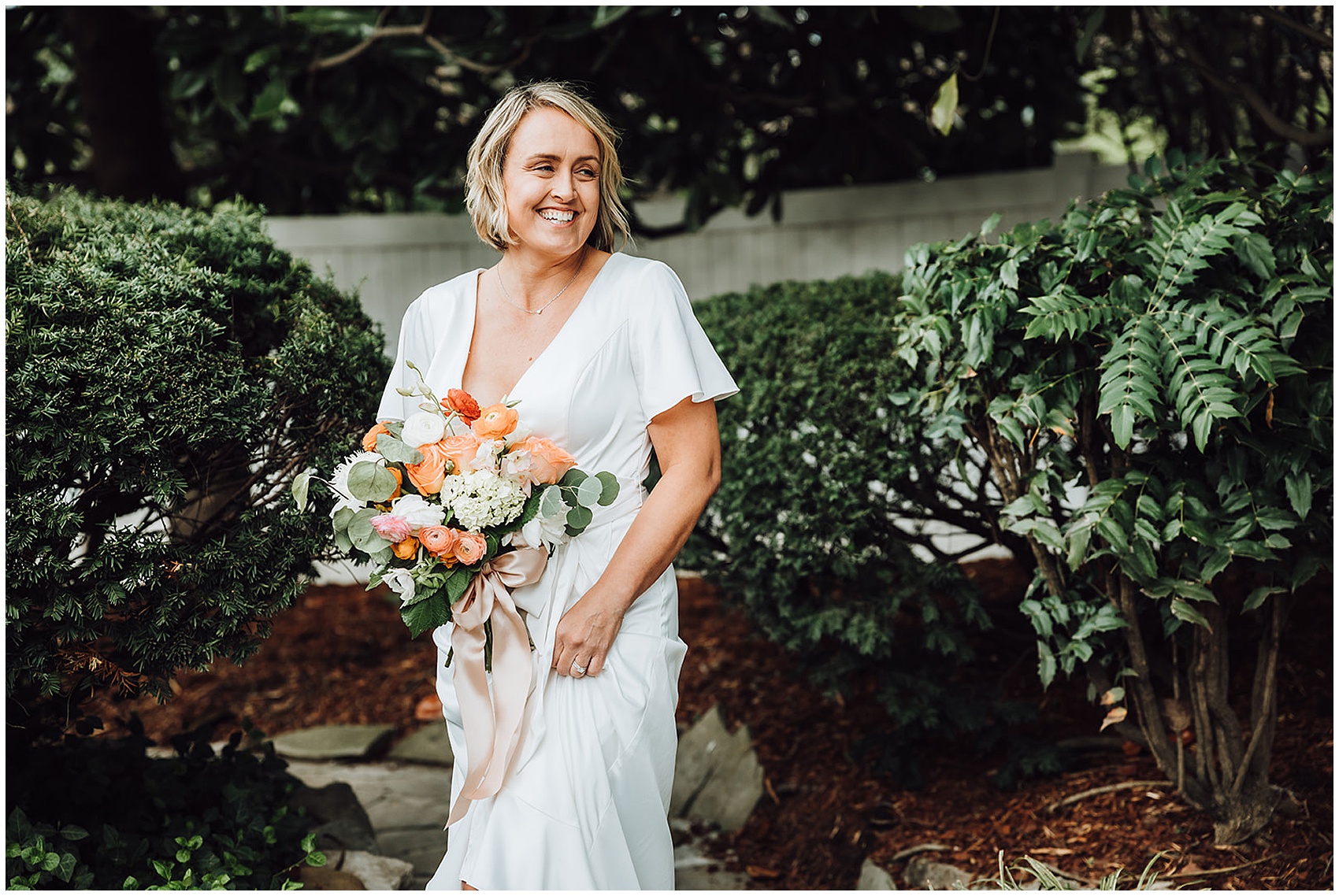 bride smiling and laughing while holding her bouquet at at CJ's Off the Square wedding venue