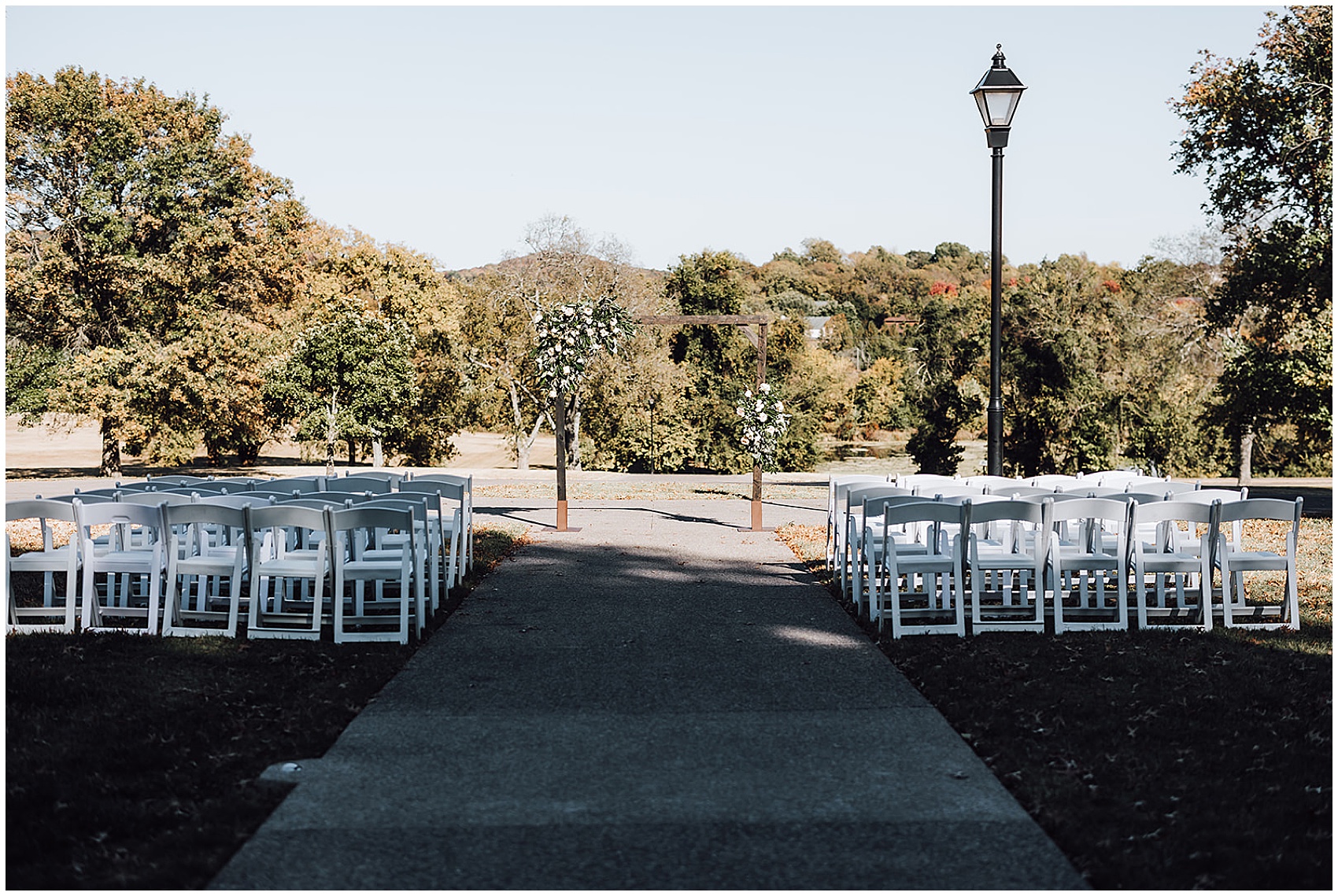 Wedding ceremony arbor and chairs decorated with white flowers