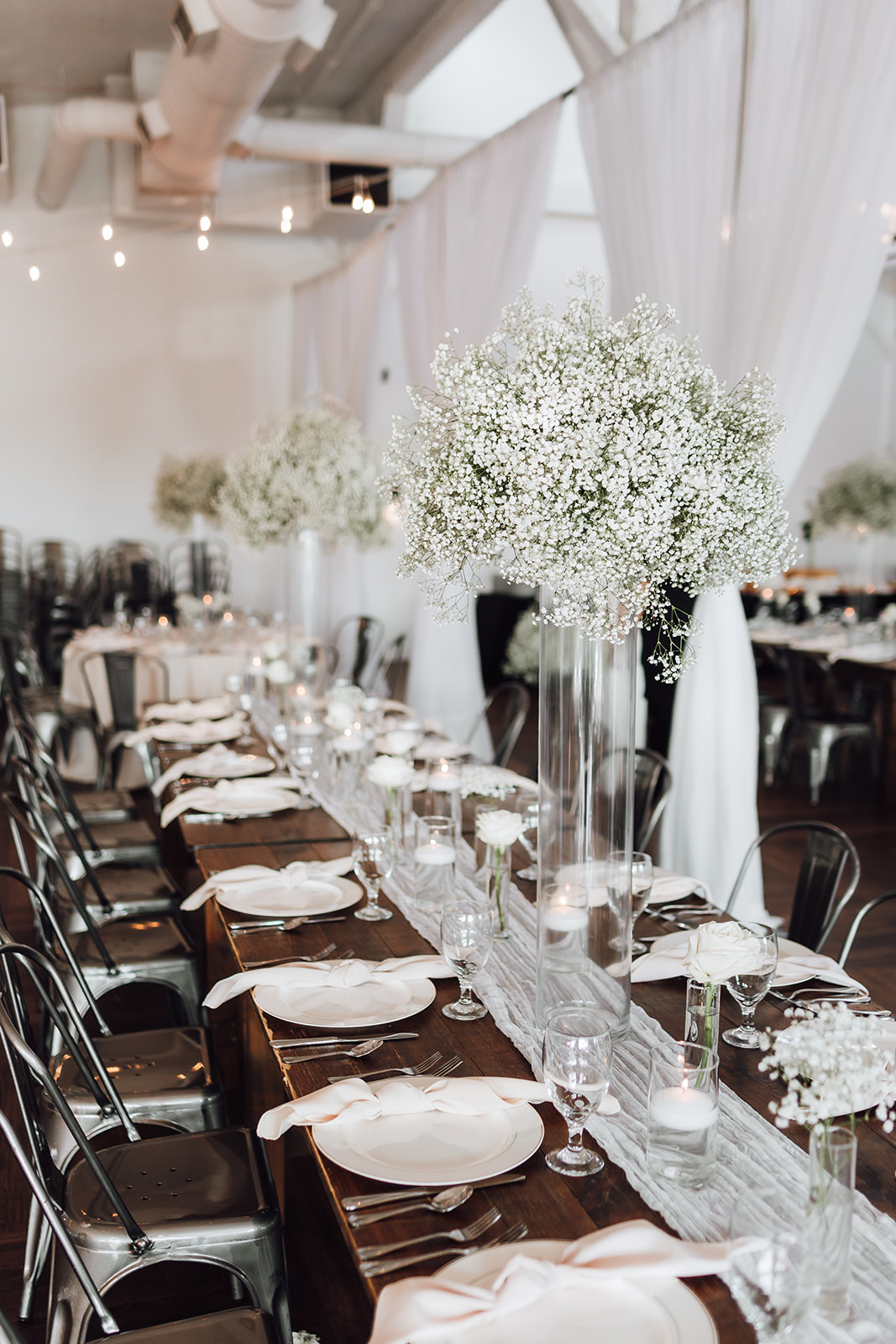 A look down a wedding reception table with white flowers and drapes 14Tenn Wedding