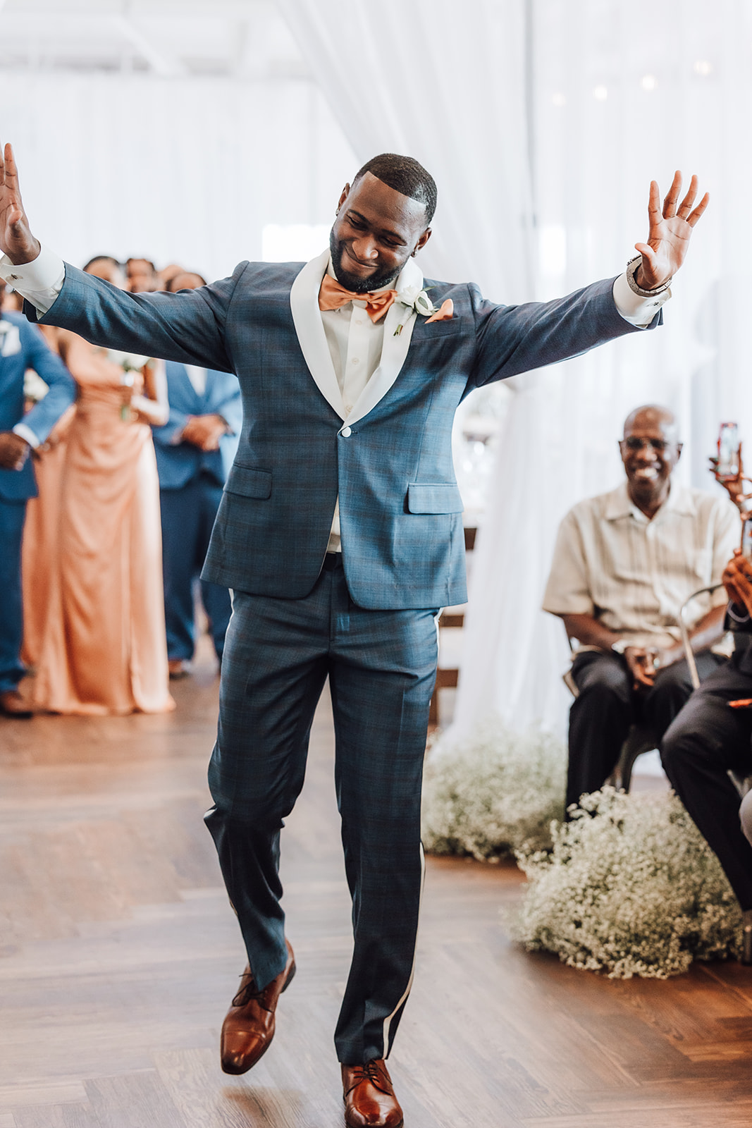 A groom in a blue suit walks down the aisle to his wedding to cheers 14Tenn Wedding