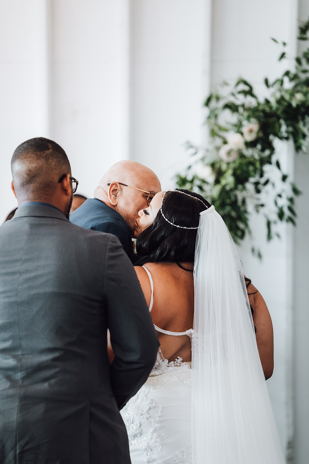 A bride hugs her father while giving her away at her ceremony