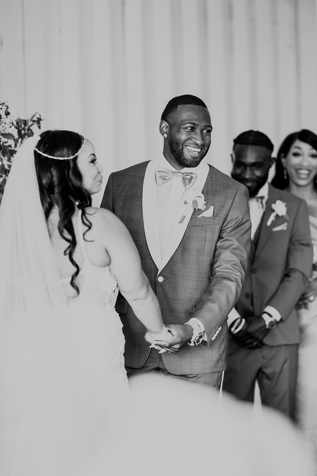Newlyweds laugh as they hold hands at the altar during their ceremony
