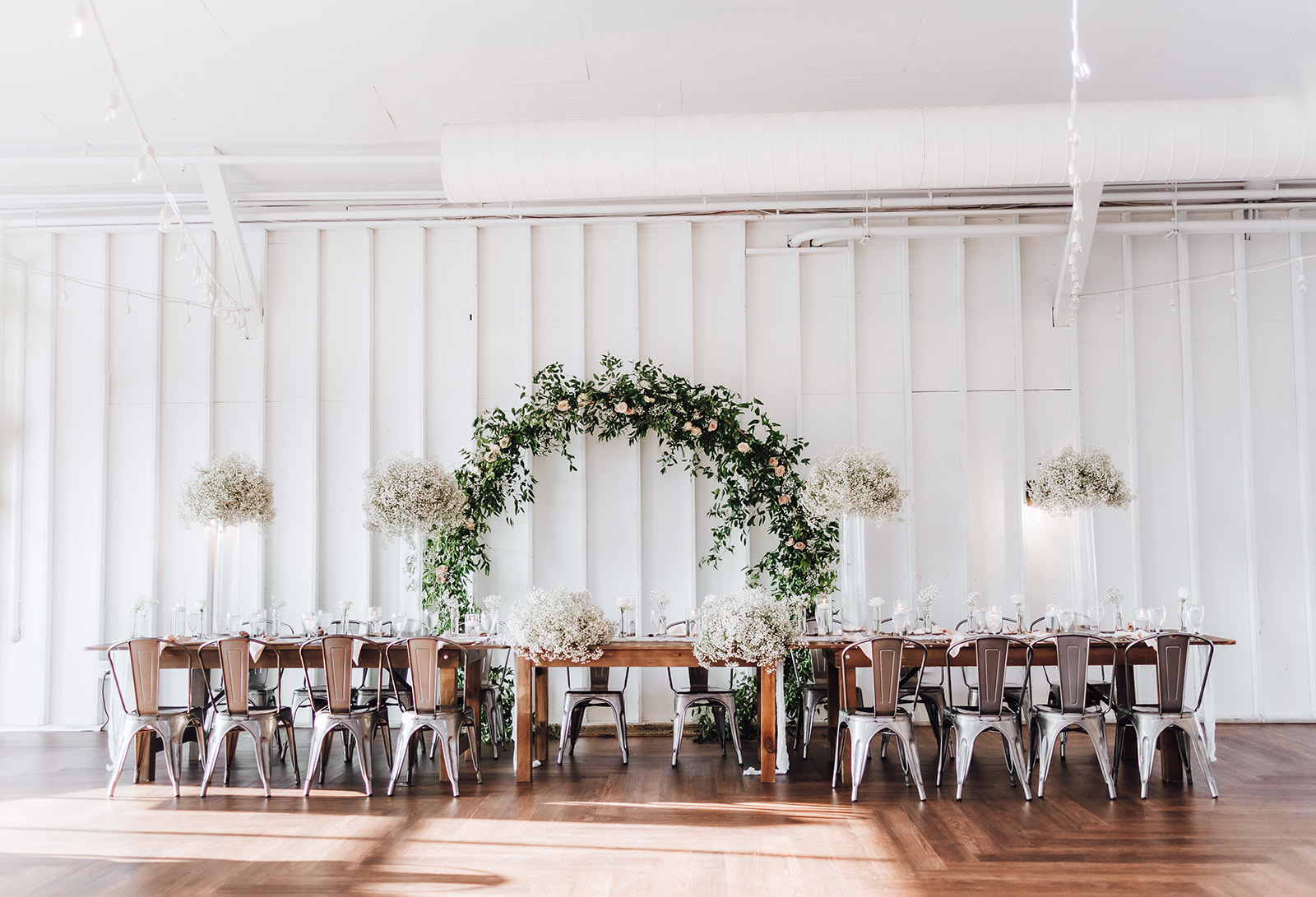 Details of a wedding reception table with white flowers and a flower arch 14Tenn Wedding