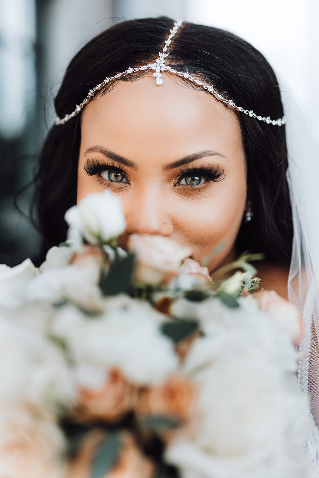 Details of a bride looking over her flowers with a diamond headpiece