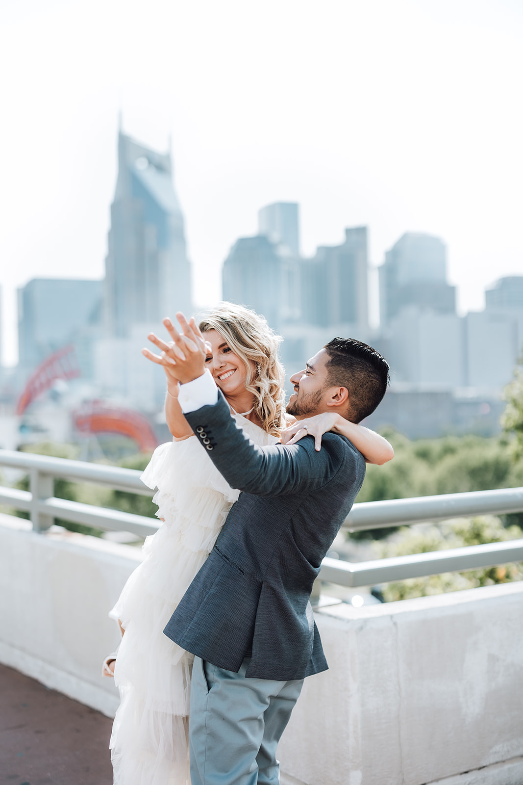 Newlyweds dance together on the roof of a building with downtown in the background at The Bridge Building Nashville
