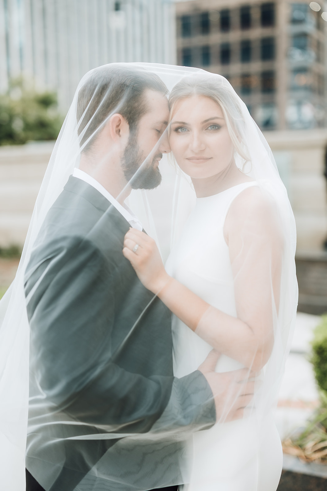 Newlyweds stand together beneath the veil at Kimpton Aertson Hotel